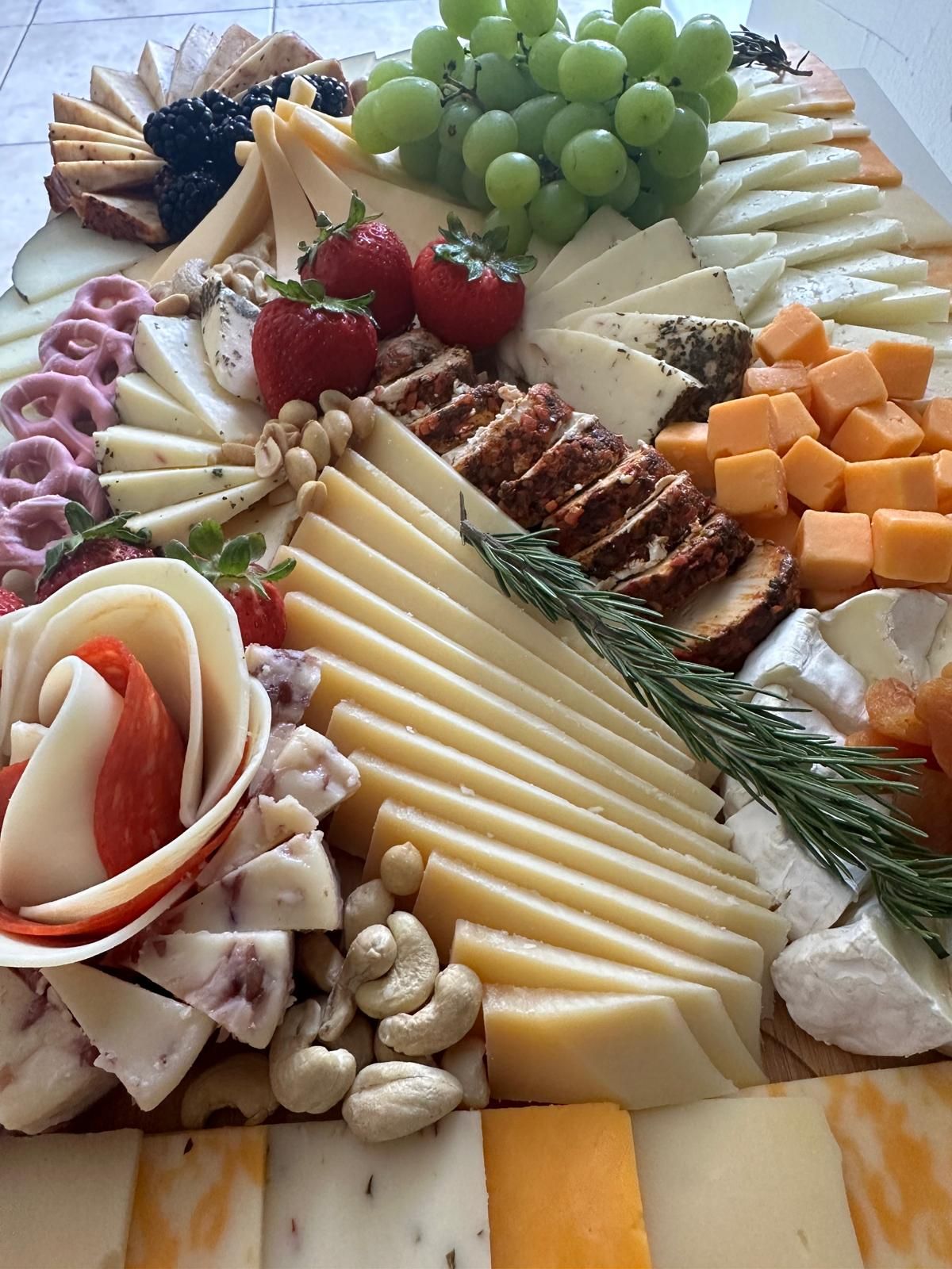 Tabla de quesos y embutidos con uvas y fresas para el cóctel